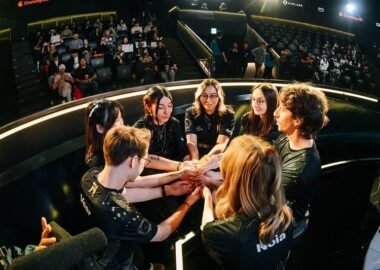 Image of members of the Shopify Rebellion VALORANT Game Changers roster sharing a team huddle on stage during an international tournament