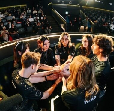 Image of members of the Shopify Rebellion VALORANT Game Changers roster sharing a team huddle on stage during an international tournament
