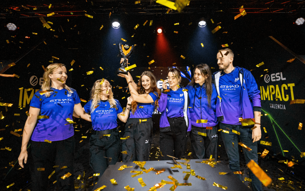 Imagem da lista de esportes eletrônicos femininos multicampeões do Nigma Galaxy comemorando outra vitória no torneio no palco cercada por confetes.