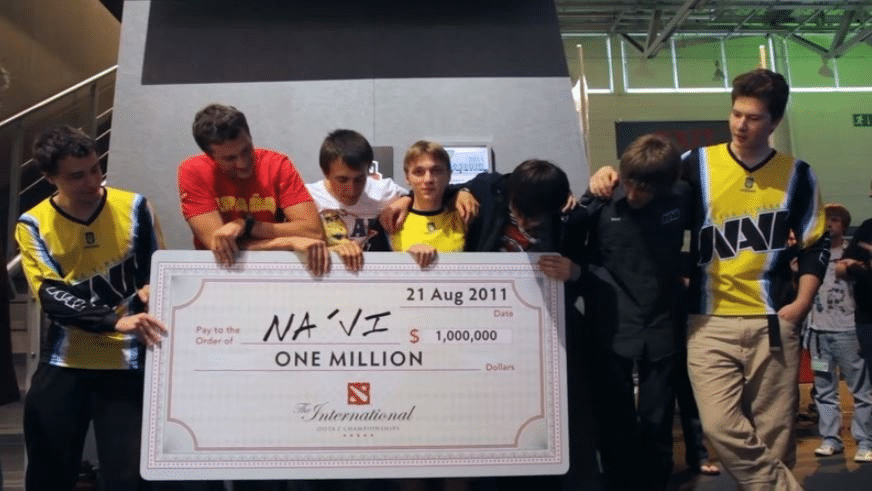 Imagem icônica de Natus Vincere segurando um cheque de um milhão depois de vencer o primeiro campeonato internacional.