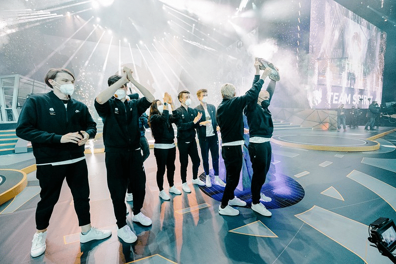 Foto do Espírito de Equipe levantando a Égide dos Campeões em frente a uma arena sem multidões no The International 2011
