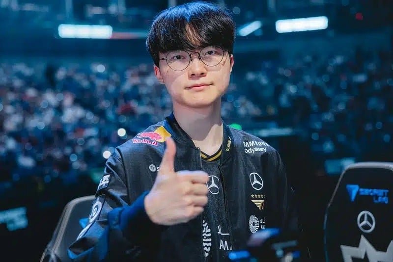 Foto do lendário jogador profissional de League of Legends Lee "Falsificador" Sang-hyeok fazendo um gesto de positivo em seu uniforme da equipe T1.