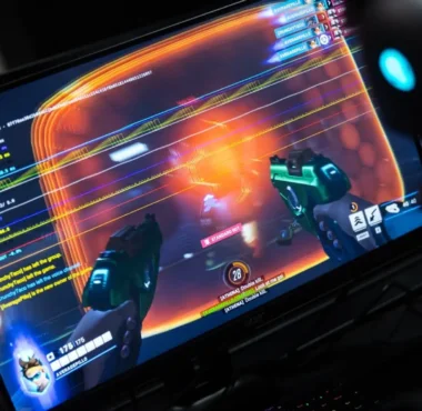 A person wearing a headset playing a first-person shooter game on a monitor.