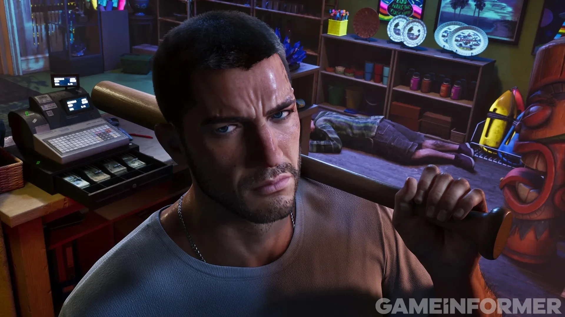 O protagonista de Grand Theft Auto VI, Jason, segurando um taco de beisebol por cima do ombro dentro de uma loja, parado perto de uma caixa registradora aberta com dinheiro visível e um funcionário nocauteado caído no chão ao fundo.   