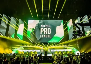 An ESL Pro League tournament stage with large screens and yellow spotlights over a crowd.