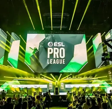 An ESL Pro League tournament stage with large screens and yellow spotlights over a crowd.