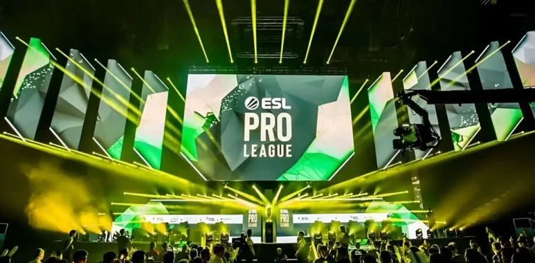 An ESL Pro League tournament stage with large screens and yellow spotlights over a crowd.