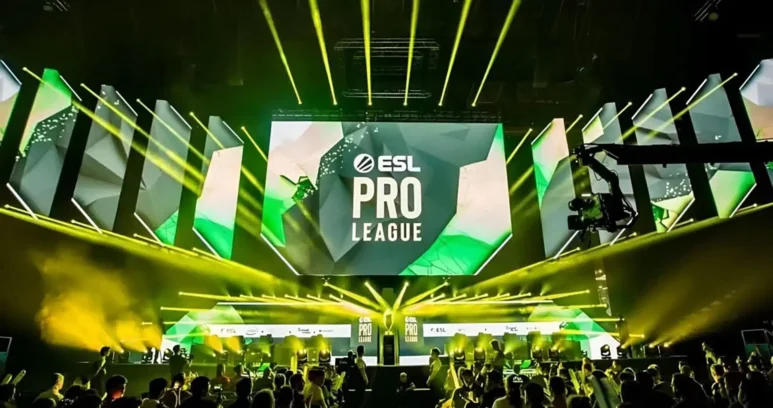 An ESL Pro League tournament stage with large screens and yellow spotlights over a crowd.