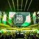 An ESL Pro League tournament stage with large screens and yellow spotlights over a crowd.
