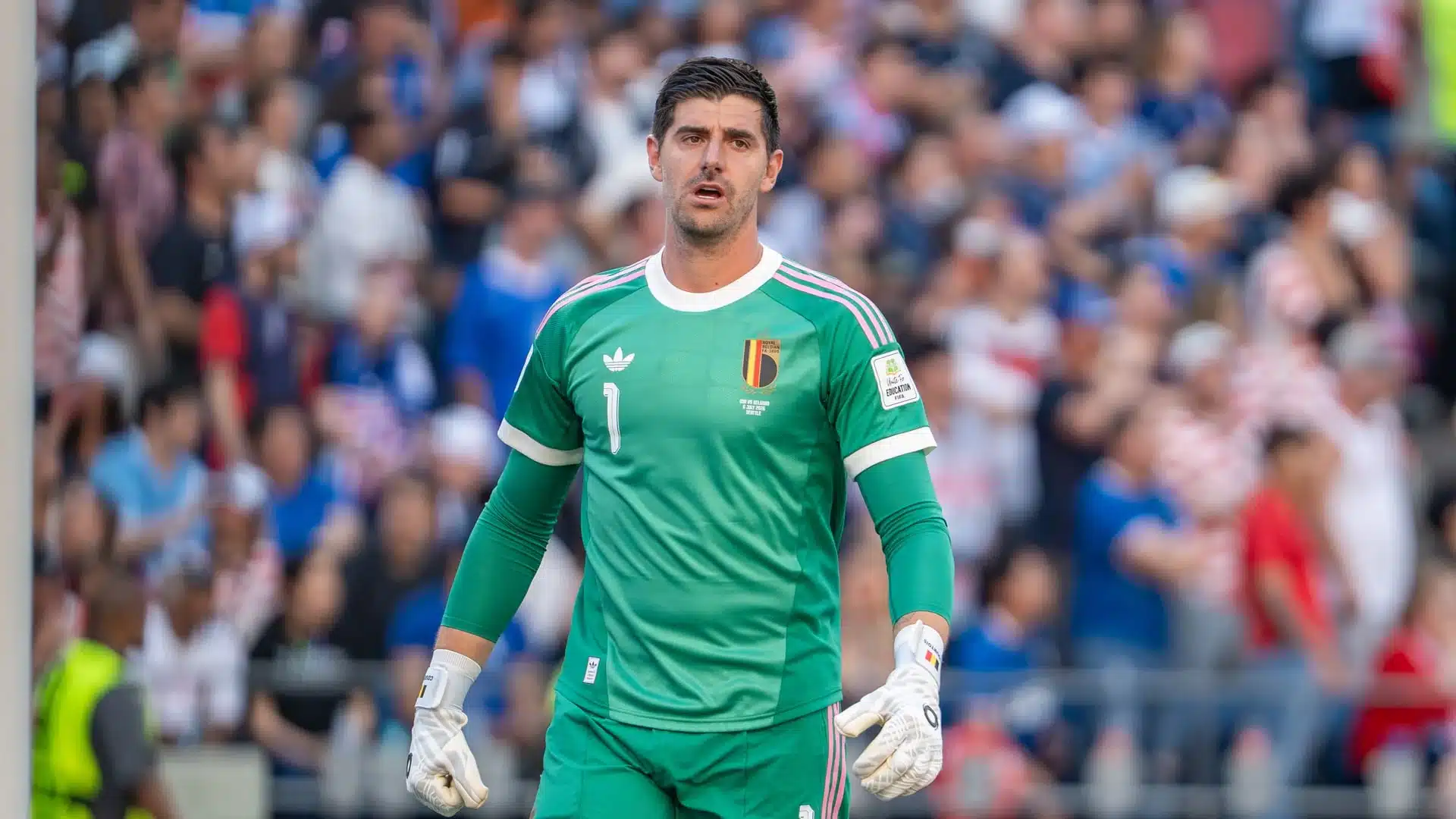 Thibaut Courtois vestindo um kit verde de goleiro da seleção belga durante uma partida.