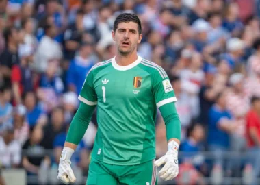 Thibaut Courtois wearing a green Belgium national team goalkeeper kit during a match.