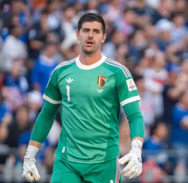 Thibaut Courtois wearing a green Belgium national team goalkeeper kit during a match.