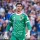Thibaut Courtois wearing a green Belgium national team goalkeeper kit during a match.