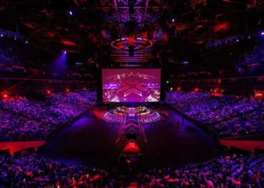 Wide shot of the Valorant Champions Shanghai arena stage and audience under red and purple lighting.