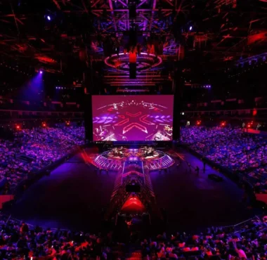 Wide shot of the Valorant Champions Shanghai arena stage and audience under red and purple lighting.