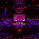 Wide shot of the Valorant Champions Shanghai arena stage and audience under red and purple lighting.