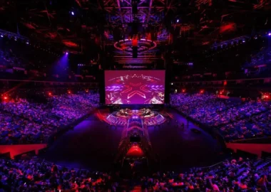 Wide shot of the VALORANT Champions Shanghai arena stage and audience under red and purple lighting.