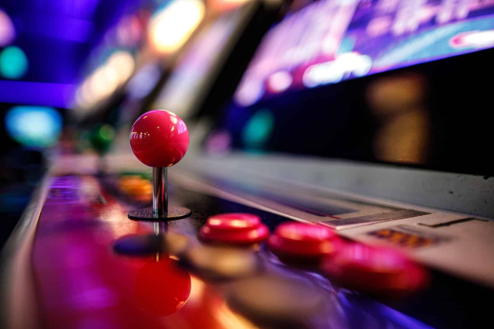 Close-up de um joystick de jogo de luta arcade e botões sob luzes de néon