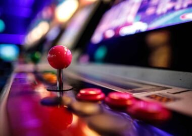 Close-up of an arcade fighting game joystick and buttons under neon lights