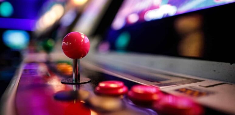 Close-up of an arcade fighting game joystick and buttons under neon lights