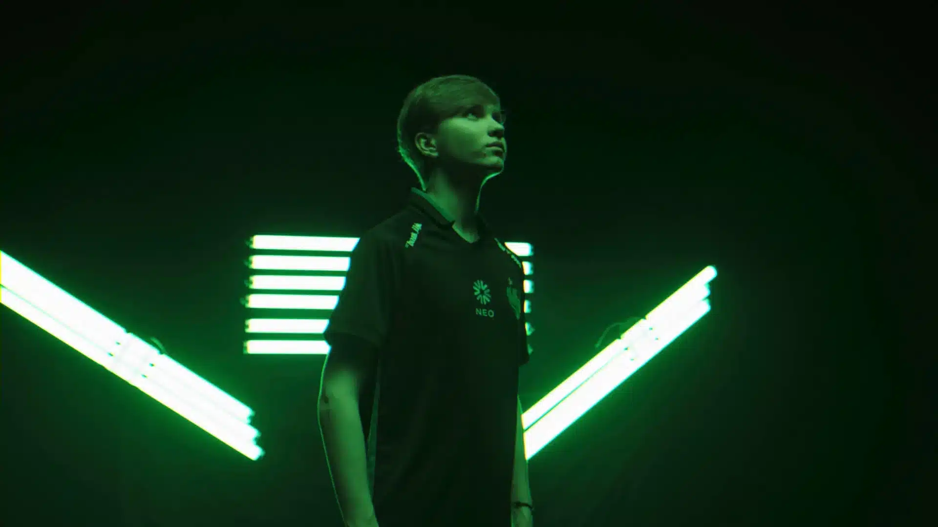 Retrato de Ilya "m0NESY" Osipov vestindo uma camisa do Team Falcons contra um fundo de luz neon verde.