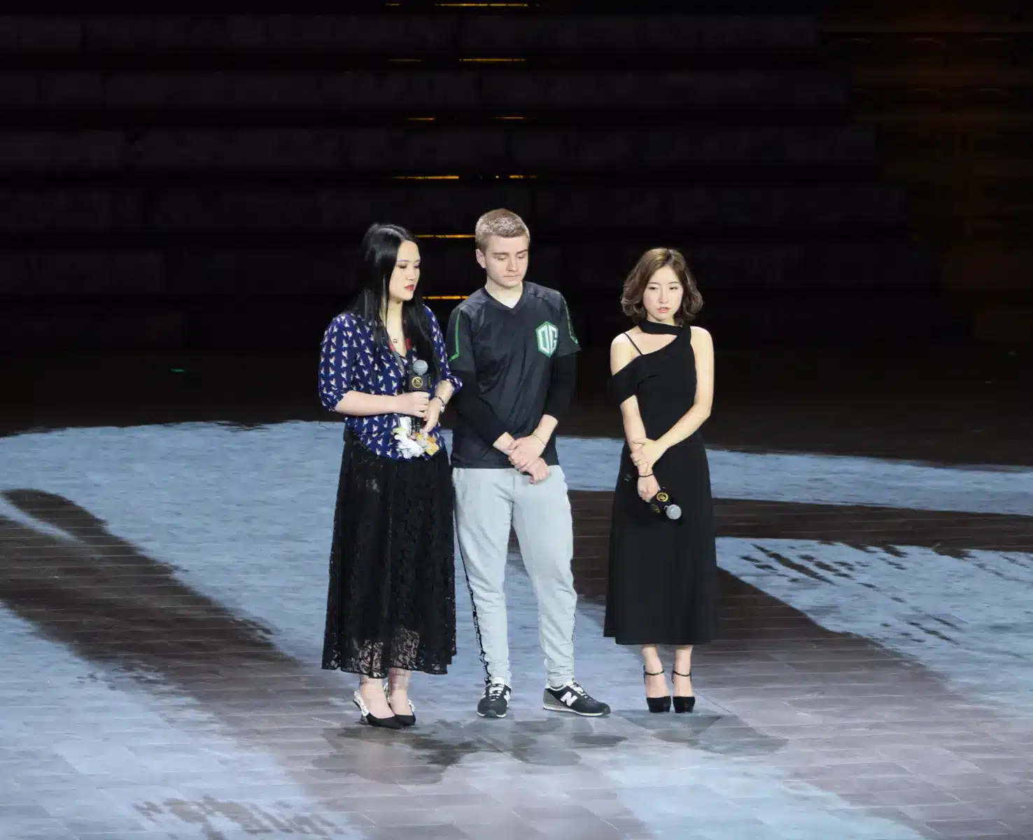 Um membro da equipe de esports da OG subindo no palco durante a entrevista de um vencedor.