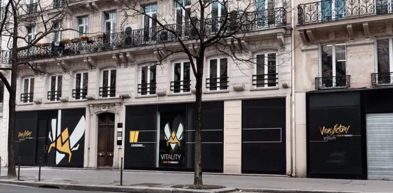 The exterior storefront of Team Vitality V.Hive in Paris, featuring the team's logo and branding on black panels.