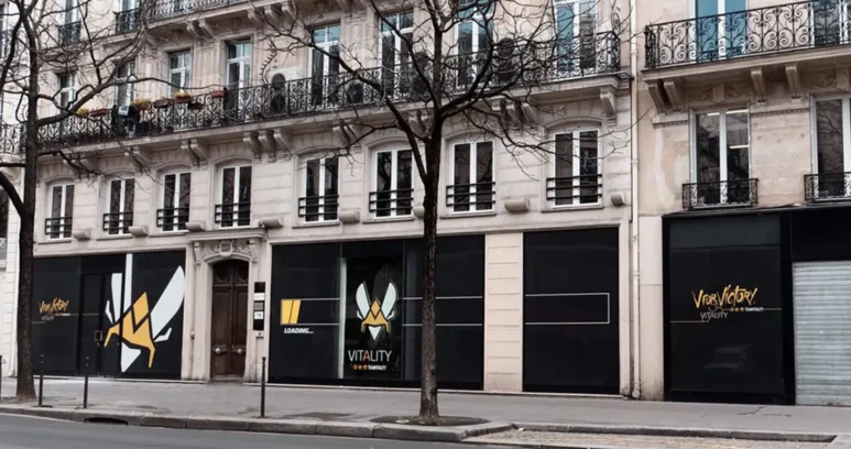 The exterior storefront of Team Vitality V.Hive in Paris, featuring the team's logo and branding on black panels.
