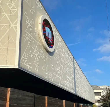 The exterior of the Riot Games headquarters featuring the company logo on the building facade.