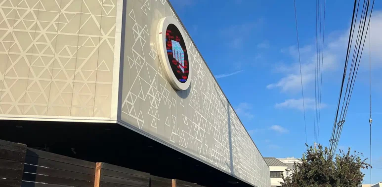 The exterior of the Riot Games headquarters featuring the company logo on the building facade.
