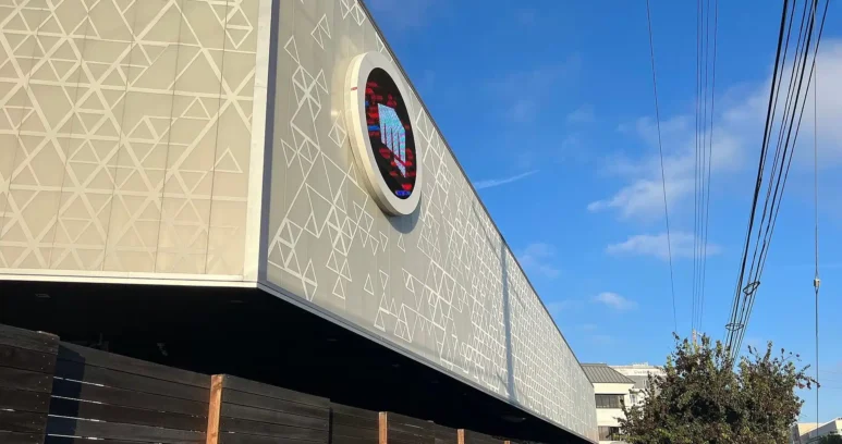 The exterior of the Riot Games headquarters featuring the company logo on the building facade.