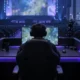 Empty Shanghai esports arena with a competitor seen from behind at an unbranded gaming station